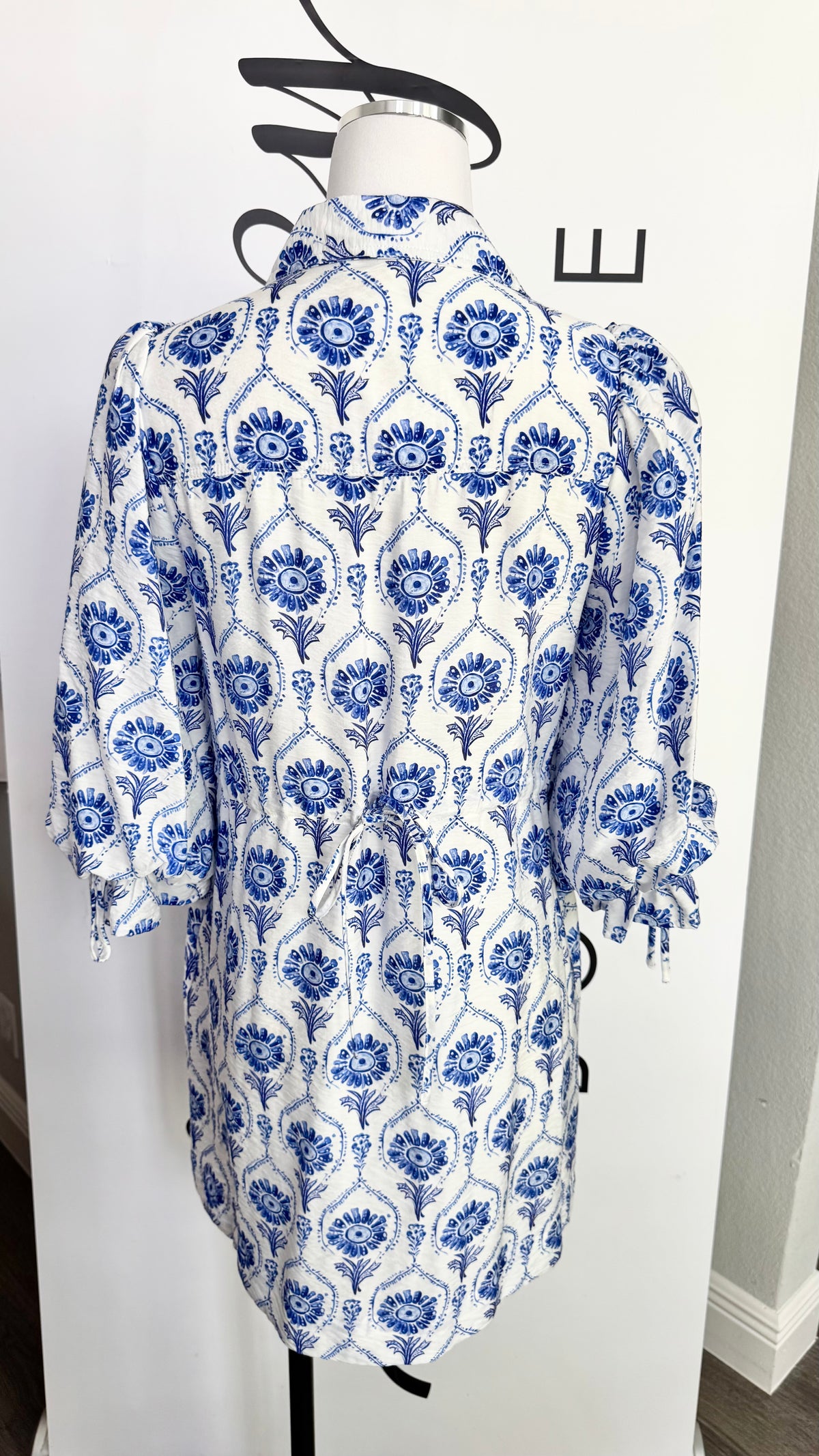 Blue and white patterned dress on a mannequin against a white background
