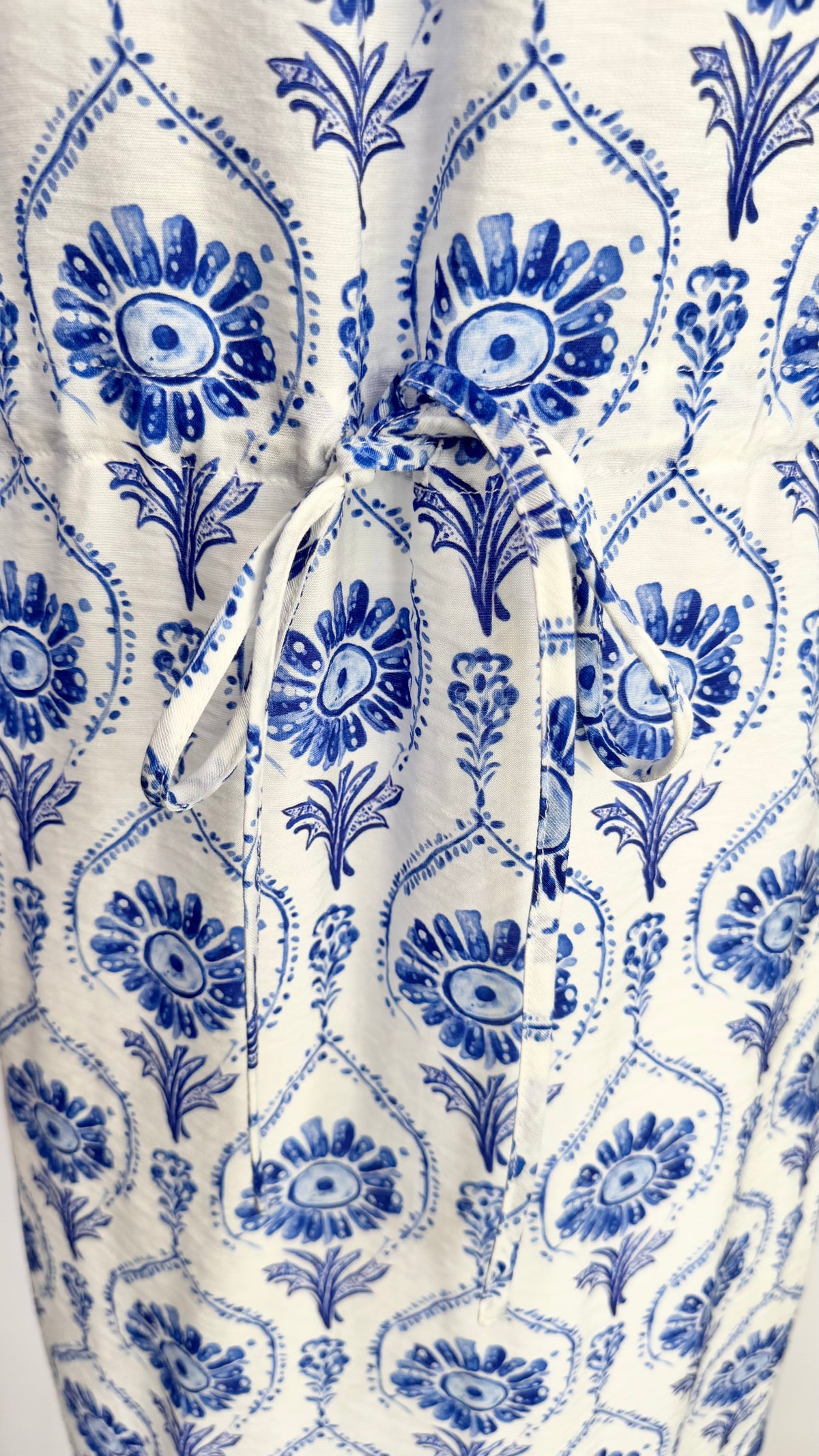 White dress with blue floral pattern on a white background
