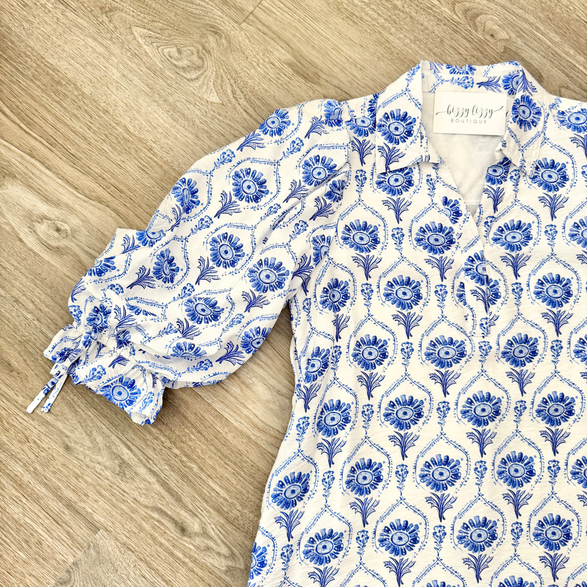 Blue and white floral patterned dress on a wooden surface