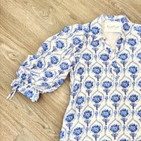 Blue and white floral patterned dress on a wooden surface