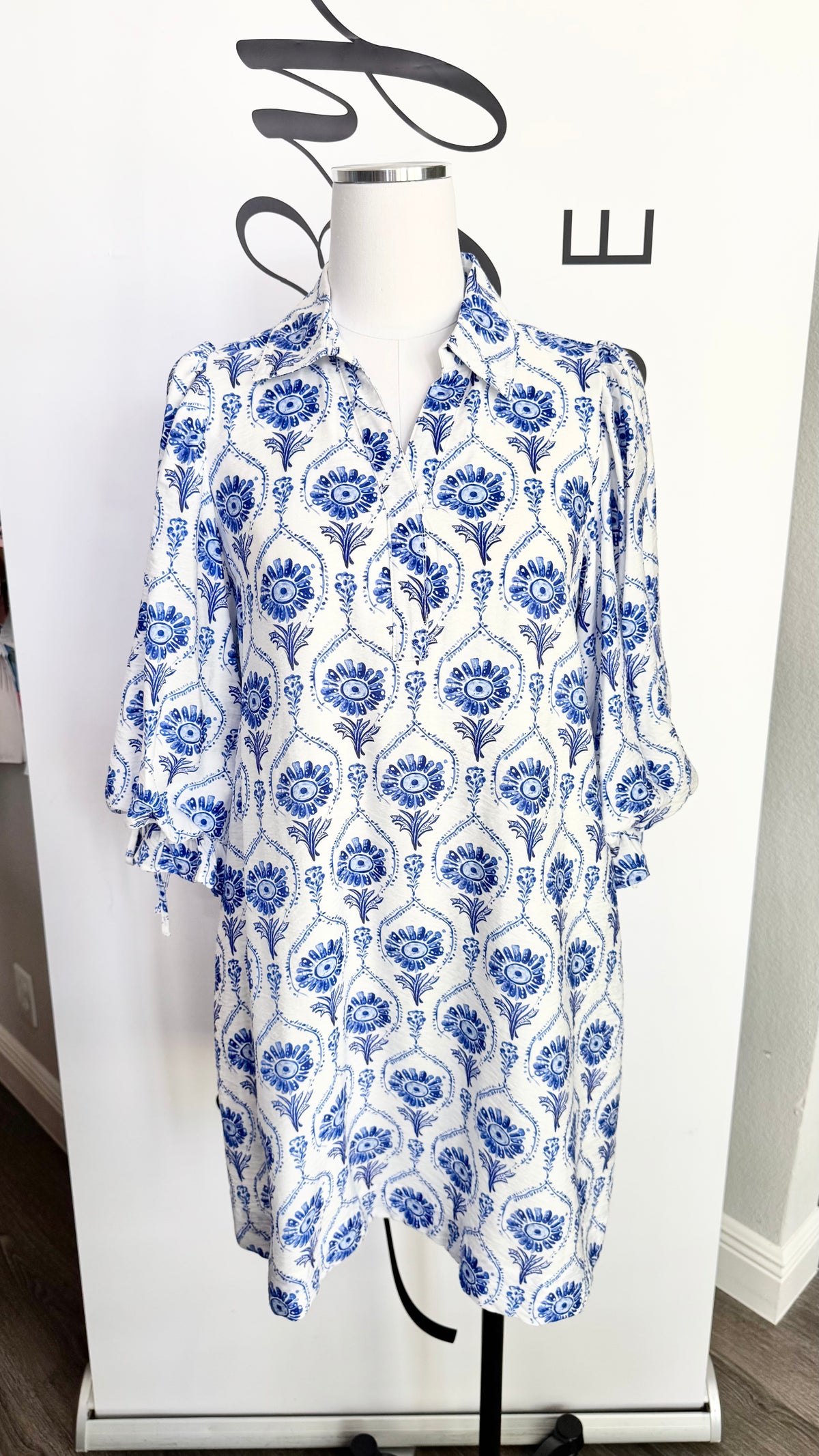 Blue and white floral patterned dress on a mannequin against a white background