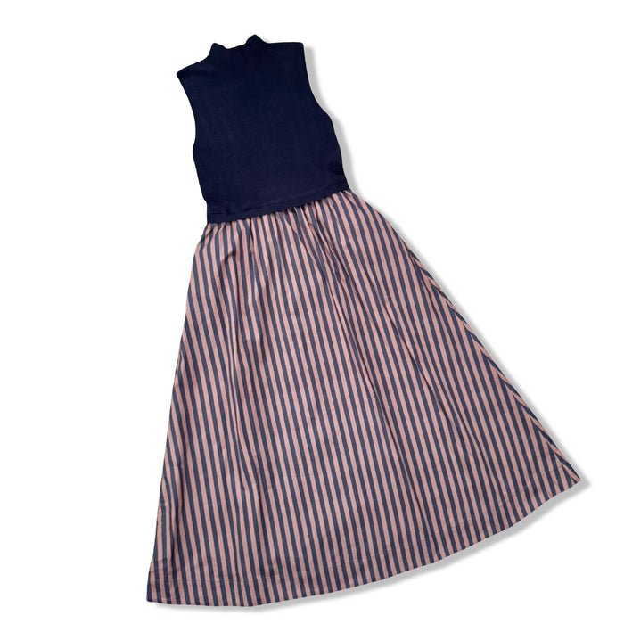 A sleeveless dress with a solid navy blue mock-neck bodice and a full skirt featuring vertical stripes in navy blue, and brown, shown on a white background.