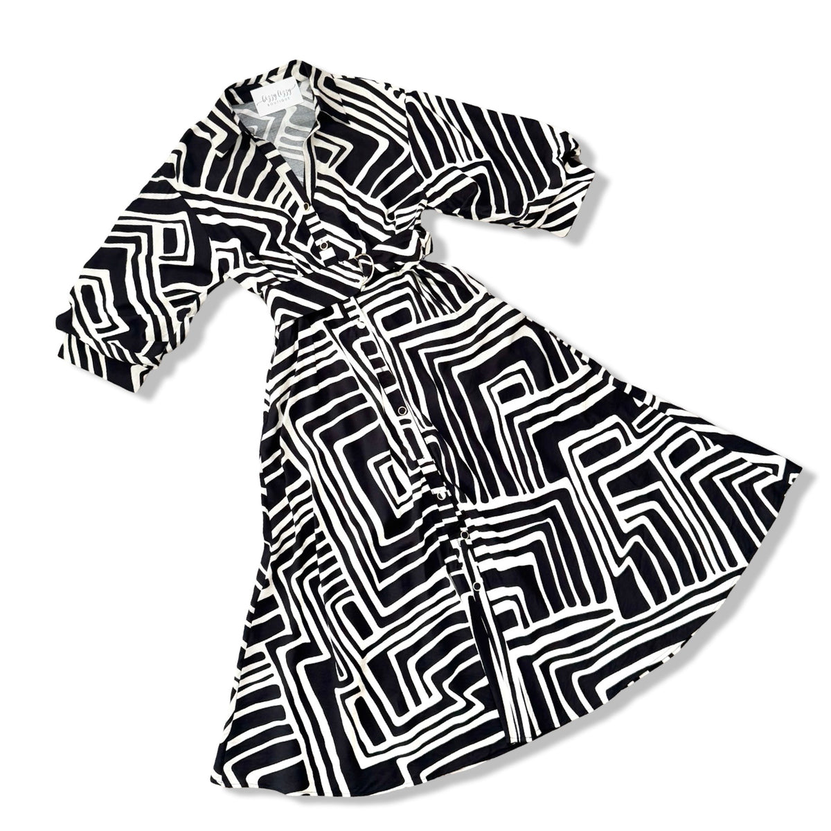 A black and white geometric patterned wrap dress with three-quarter sleeves, displayed on a clean white background.
