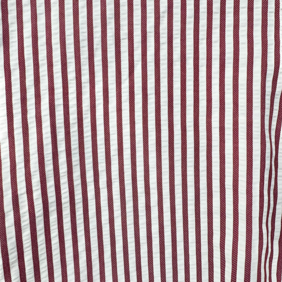 A close-up of a vertically striped fabric pattern with alternating dark burgundy red and off-white stripes.