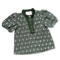 A dark green short-sleeve blouse with a white geometric pattern, featuring a ruffled collar, buttoned placket, and puffed sleeves, laid flat on a white background.