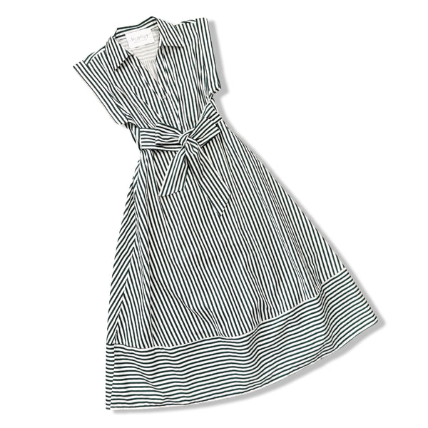 A sleeveless collared dress with vertical black and white stripes, featuring a tie waist and a tiered skirt, shown on a plain white background.