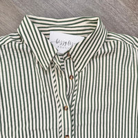 A close-up of a button-down shirt with vertical green and off-white stripes, featuring a white neck label that reads 'bizzy boutique' and brown buttons.