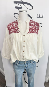 White game day blouse with maroon embroidered details on a mannequin against a white background