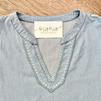 Light blue denim shirt with a 'Lizzy Lizzy Boutique' tag on a wooden surface