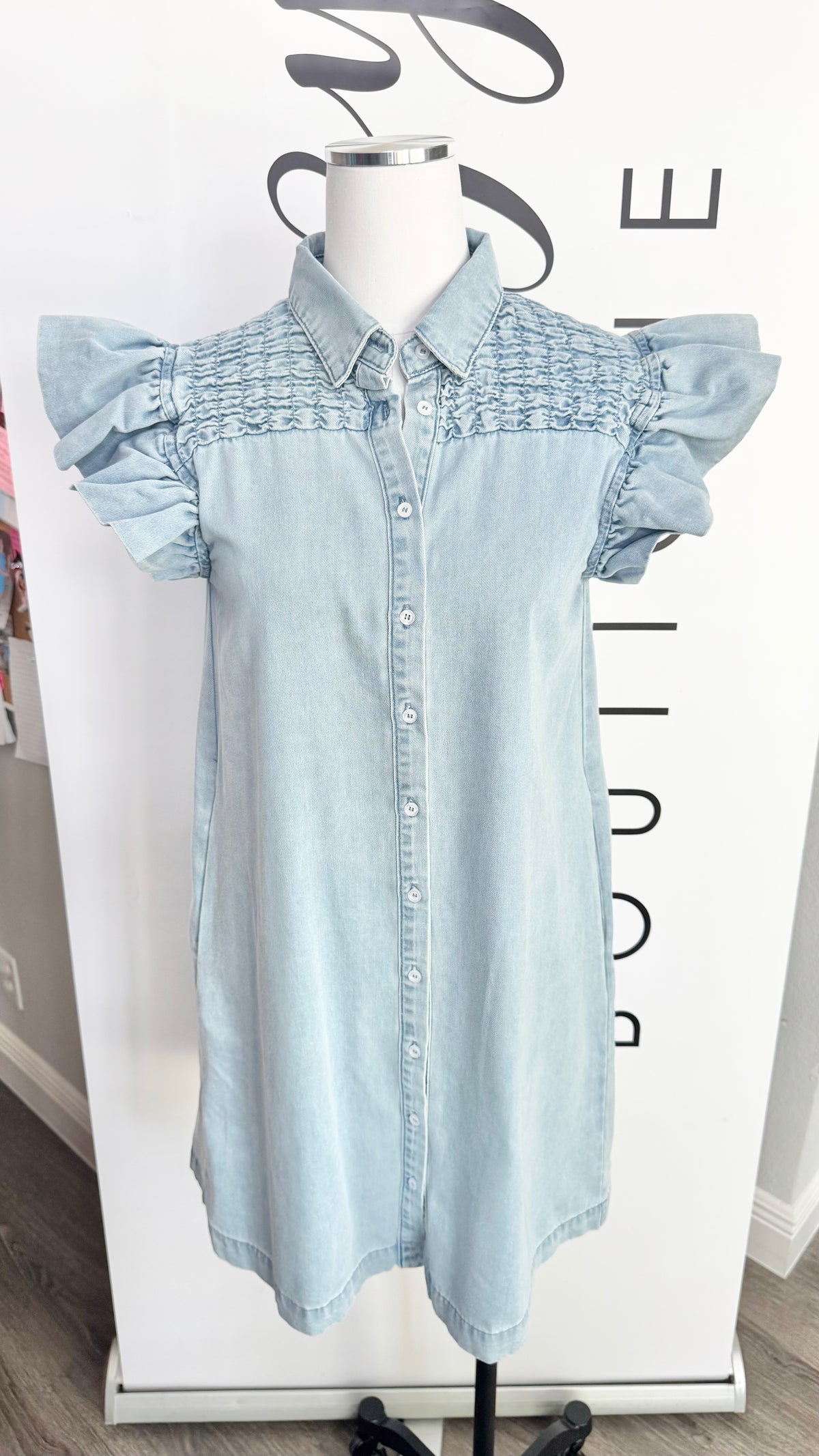 Light blue denim dress on a mannequin with a blurred background