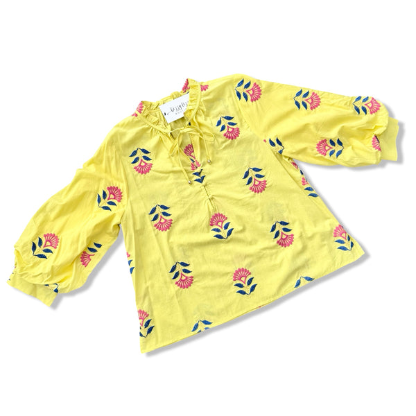 Yellow blouse with floral patterns on a white background