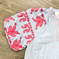 Light Blue Top with red floral embroidery on a wooden surface
