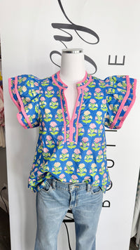 Mannequin wearing a blue floral blouse with pink accents on a white background