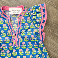 Floral-patterned dress with pink trim on a wooden surface, featuring a 'Bizzy Lizzy Boutique' tag.