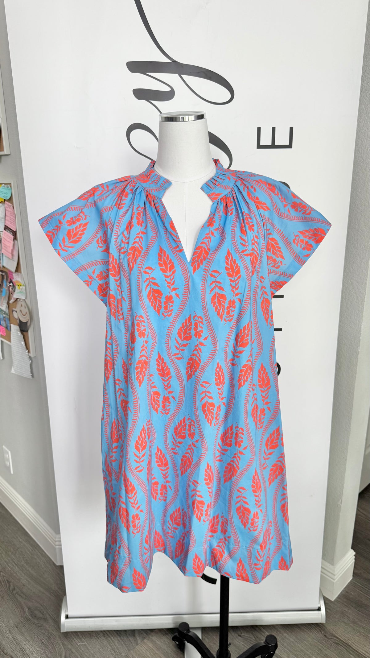 Blue and orange patterned dress on a mannequin against a white background