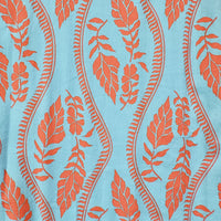Patterned fabric with orange leaves and wavy lines on a light blue background