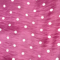 A close-up of maroon fabric with a white polka dot pattern.