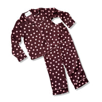 A two-piece pajama set consisting of a long-sleeve button-front top and matching pants, both in a dark plum-burgundy color with a light pink polka dot pattern and white piping, shown on a plain white background.