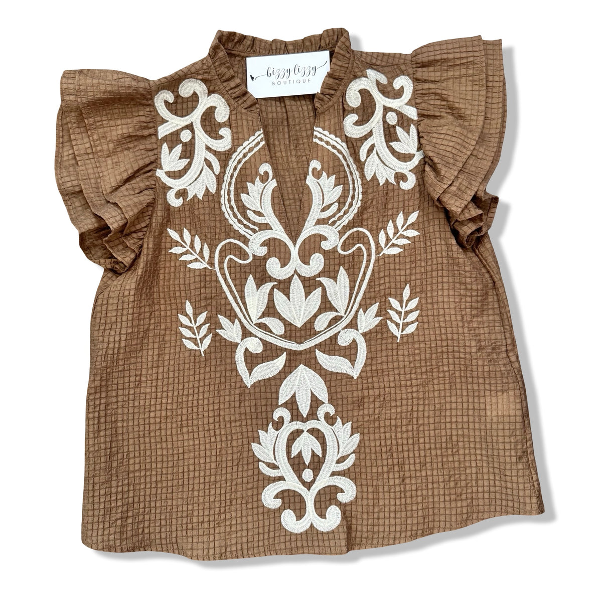 A brown textured cotton blouse with white embroidered floral patterns on the front, featuring ruffled short sleeves and a V-neckline, laid flat on a white background.
