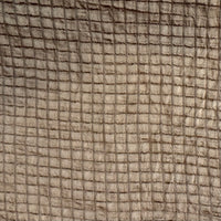 A close-up of a textured fabric with a grid-like woven pattern in warm taupe and brown tones.